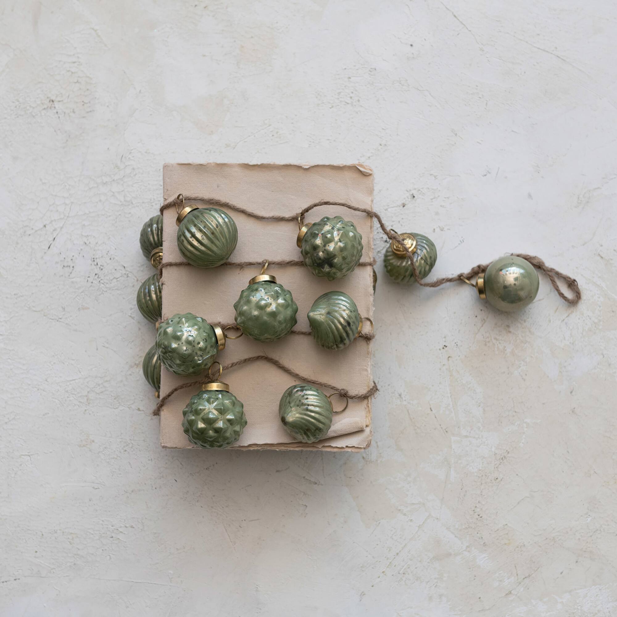 Hello Honey® 6ft. Olive Green Embossed Mercury Glass Ball Ornament Garland